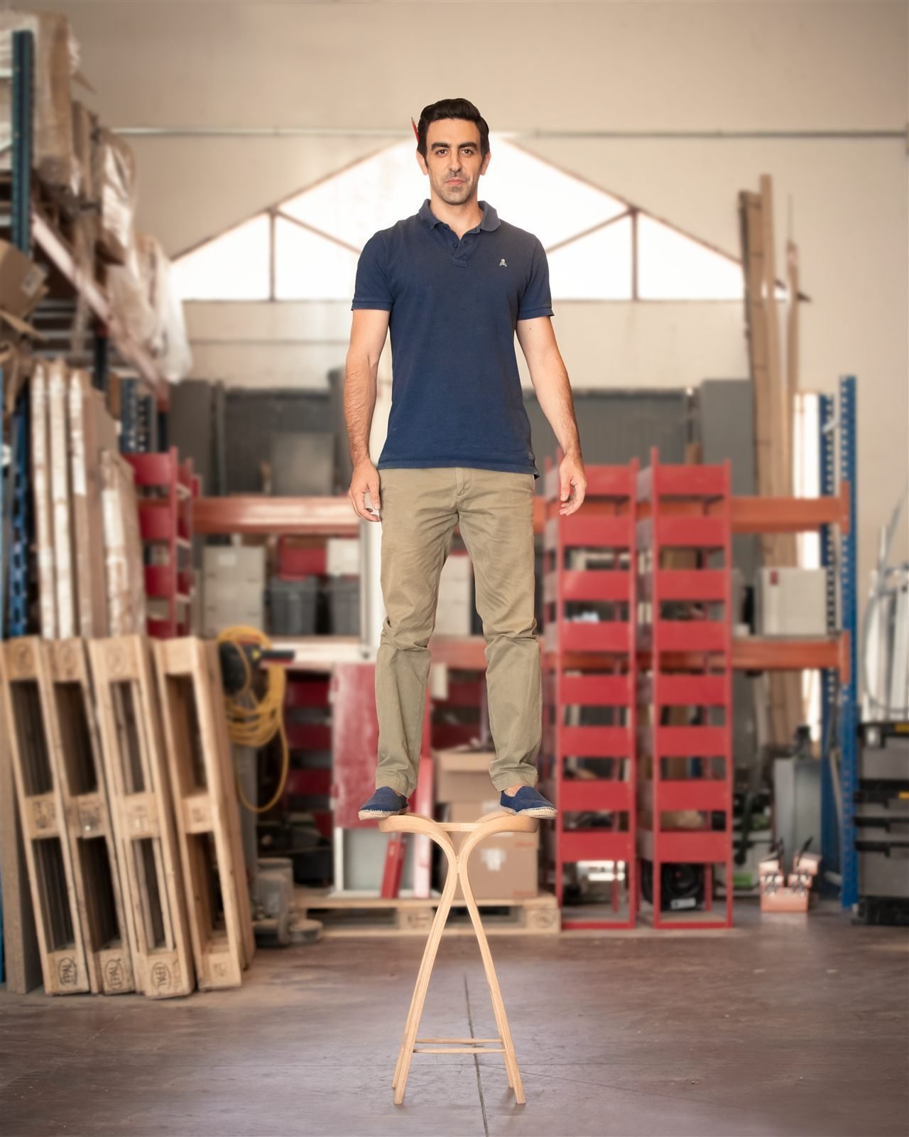 Andrés Mariño Maza standing on a stool in his workshop