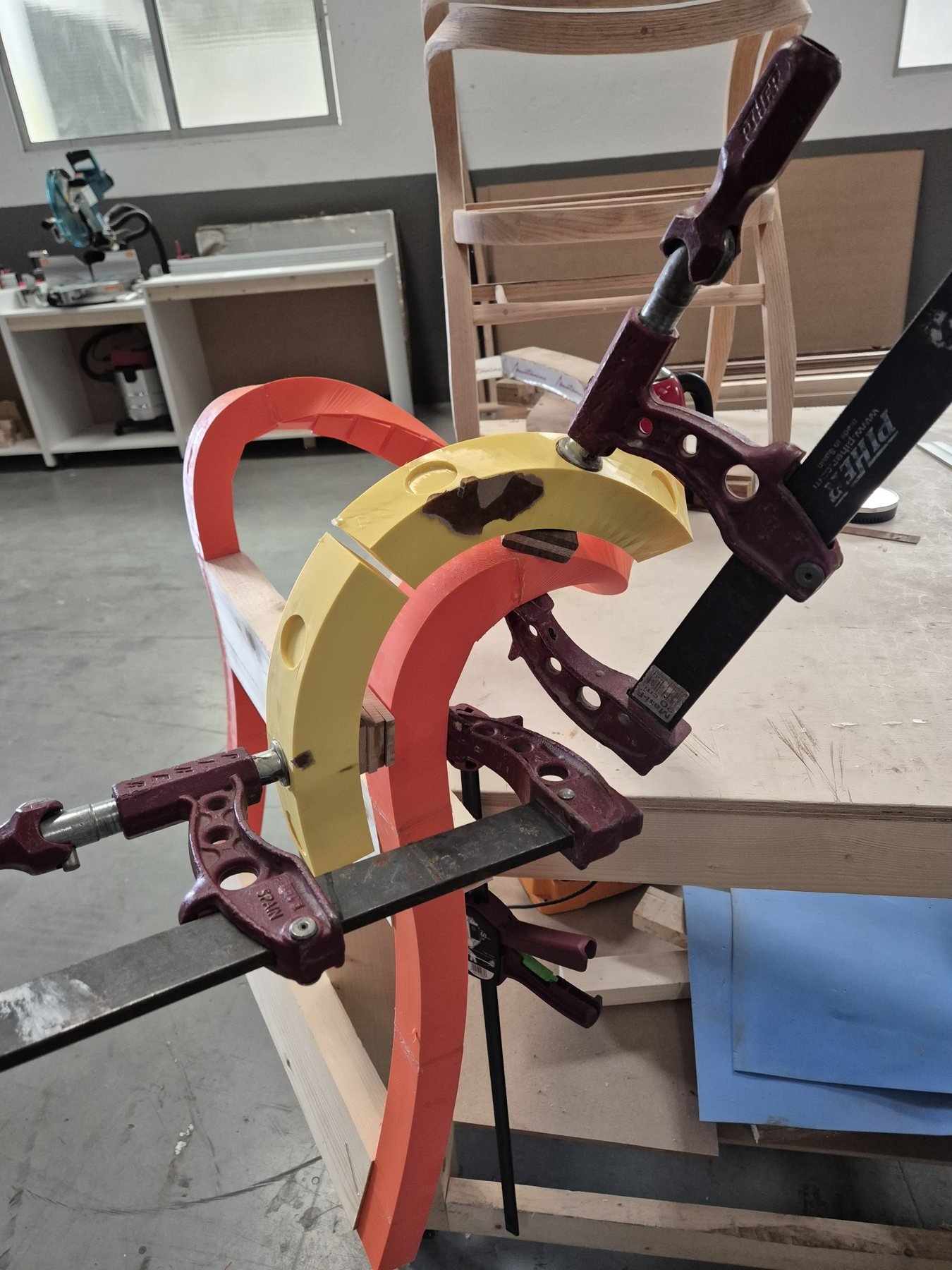 3D-printed bending forms clamped onto a steam-bent frame in the workshop