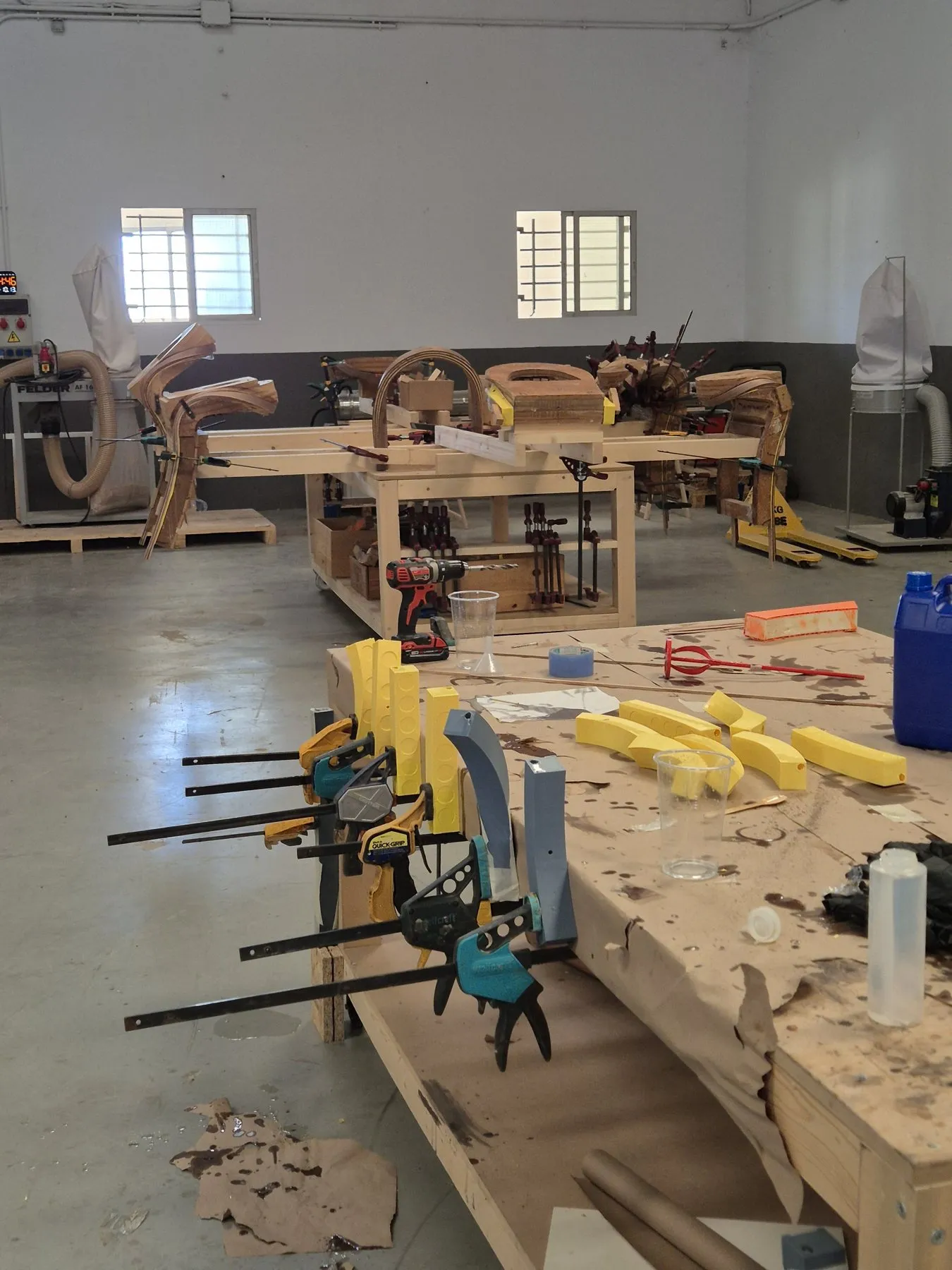 Workbenches with clamps and 3D-printed parts in the workshop